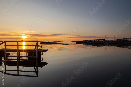 Beautiful summer evening with a spectacular sunset over the Gothenburg Archipelago and the calm water of the North Sea seen from the rocky coastline of the small island Vrango with a swimming jetty