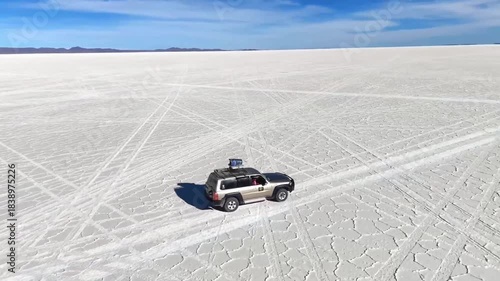 Off-Road Vehicle Driving on Vast White Salt Flats Under Blue Sky