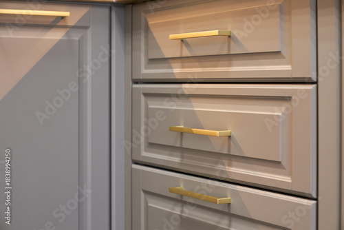 Kitchen cabinets with golden handles in a modern setting