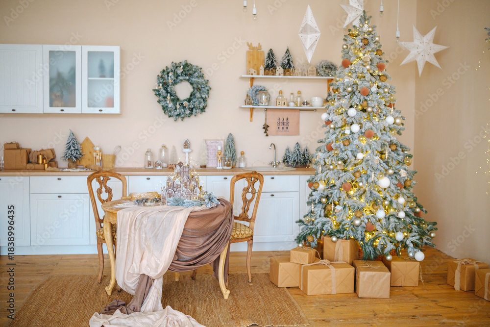 Obraz premium Cozy kitchen decorated for winter holidays with a lit Christmas tree and festive table setting.