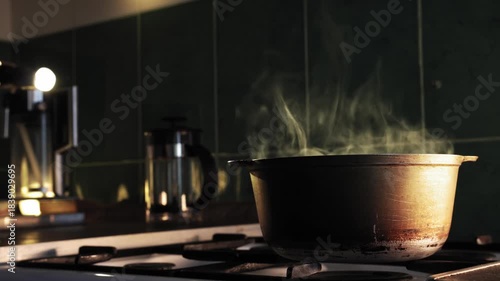 Wallpaper Mural In dark kitchen background a man pours pasta into pot of boiling water on stove Torontodigital.ca