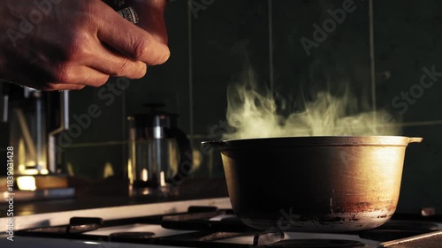 Wallpaper Mural A man In kitchen adds a few pinches of salt to a steaming pot on a gas stove. Torontodigital.ca