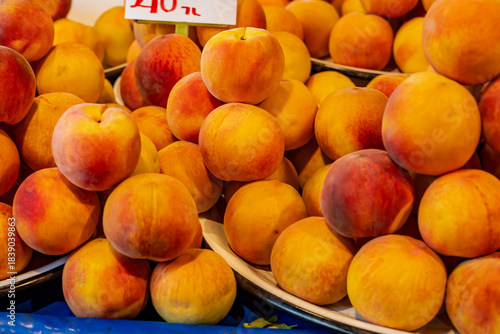 Fresh, large, ripe peaches at the neighborhood market stall.