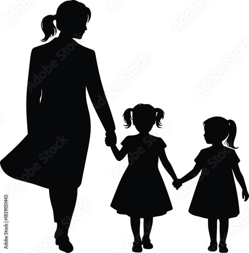 Silhouette of woman walking with two young girls holding hands