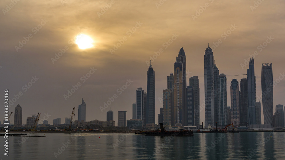 Fototapeta premium Panorama of modern skyscrapers in Dubai city at sunrise timelapse from the Palm Jumeirah Island.