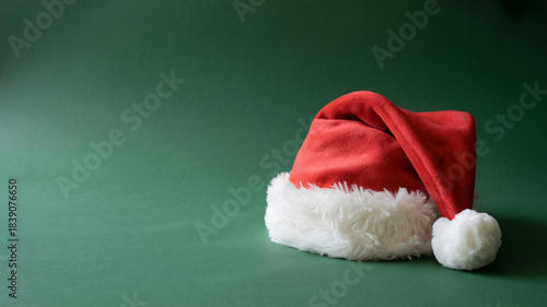 Classic Plush Santa Hat with White Fur on Deep Green Minimalist Background
