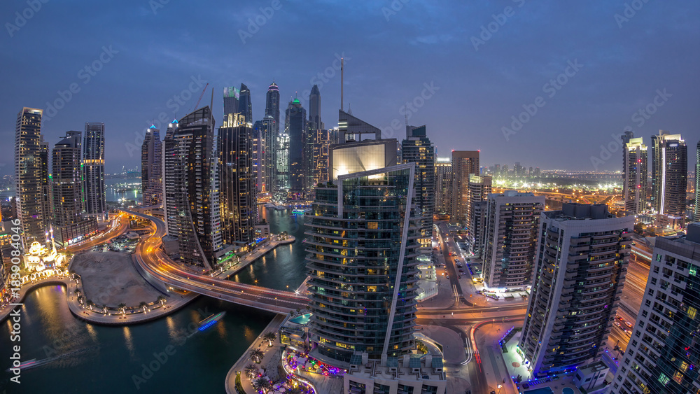 Obraz premium Aerial view of Dubai Marina residential and office skyscrapers with waterfront day to night timelapse