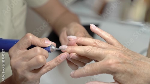 Step by Step French Manicure Process With Pastel Polish for Mature Hands. Nail treatment with milling cutter
