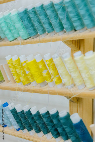 Rows of spools of thread are displayed on shelf. Coils of different colors, sizes are neatly and orderly arranged. concept of organization and attention to detail. sewing industry, hardware store.