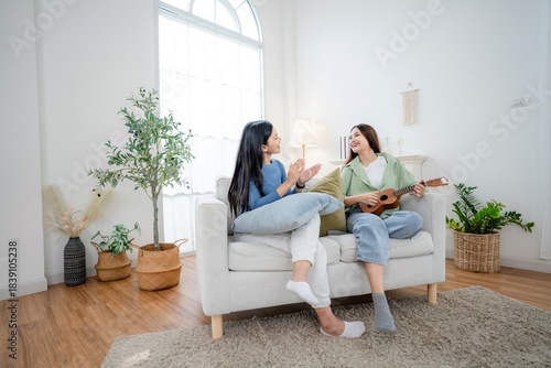 Two friends play and sing together in a bright living room while enjoying each other’s company