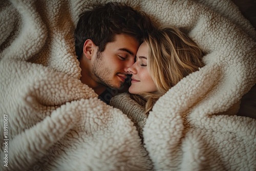 Young lovers spend a pleasant time together under a white blanket