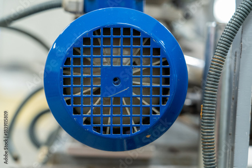 Close-up of blue electric motor fan cover with grid pattern