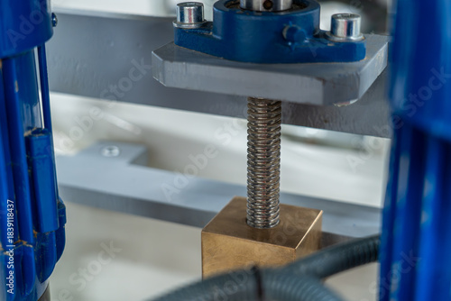 Close-up of metal lead screw and bronze nut in industrial adjustment mechanism