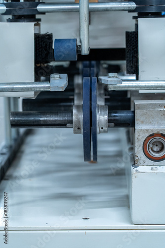 Vertical view of industrial machine rollers and metal shaft in production line
