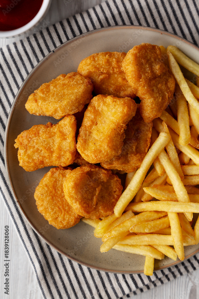 Naklejka premium Chicken Nuggets with French Fries on a Plate, top view.