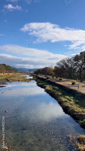 Kamogawa River, Kyoto, blue sky and white clouds on a winter day in Japan; Vertical; Video