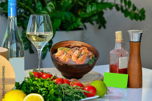 Varenf crayfish in a clay plate on a table with white wine and food decor in the rays of the sun
