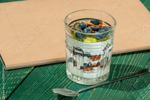 teramis in a glass decorated with blueberries and granola macro photo