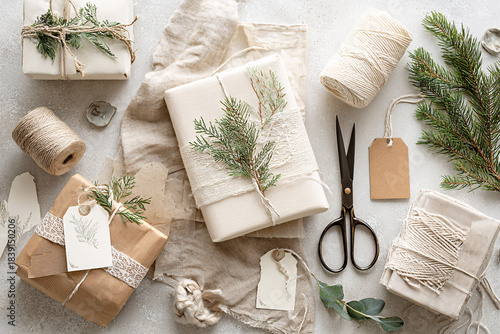 Neutral Eco-Friendly Holiday Gift Wrapping Flat Lay with Kraft Paper, Twine and Evergreen on Light Textured Background