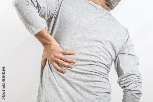 The older man grabbed his lower back. Radiculitis symptom, inflammation, pain in the spine of the senior man.