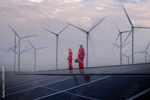engineer working on solar cell plant with windmill field .Solar cell smart grid and windmill are ecology energy renewable sunlight alternative green power environment factory concep.t