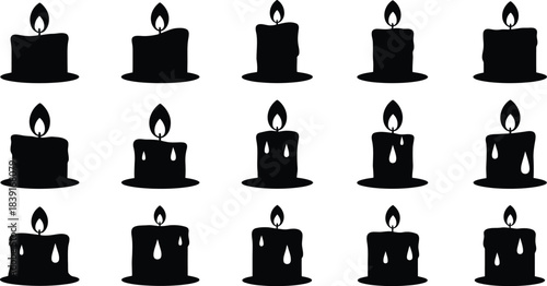 Arrangement of black candles with flickering flames on white
