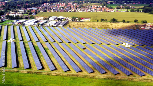 Aerial view of a solar farm on green fields, capturing sustainable energy with countless photovoltaic panels