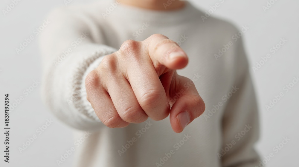 Naklejka premium Close up of a person's hand pointing directly forward wearing a light sweater