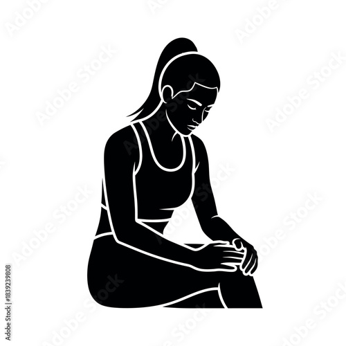 Woman in sportswear sitting and holding her knee.