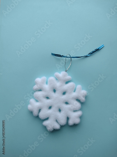 Snowflake Christmas tree toy on a blue background.