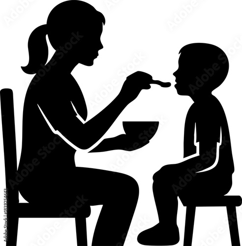 Silhouette of woman feeding child with spoon in gentle caring moment