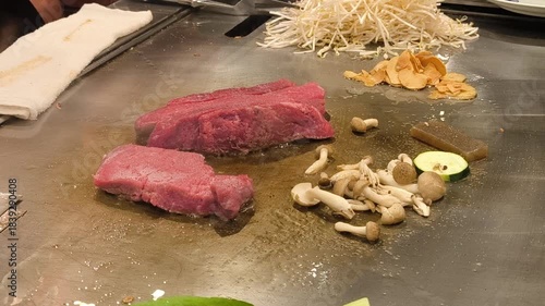 A skilled chef cooks premium Kobe steak with precise movements at the counter