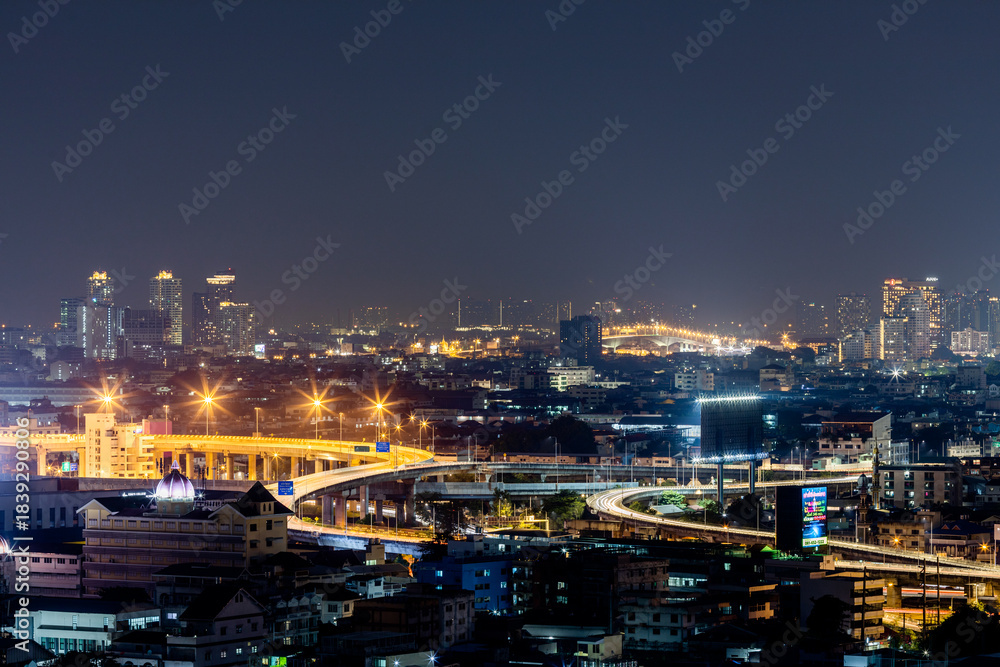 Obraz premium The high angle background of the city view with the secret light of the evening, blurring of night lights, showing the distribution of condominiums, dense homes in the capital community