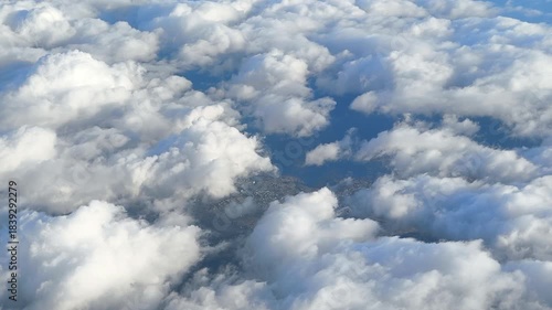 Puffy formations slide past the window, giving a dynamic aerial perspective