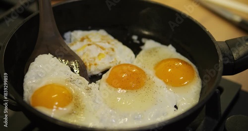 Frying eggs in a pan. Flipping the egg with a spatula