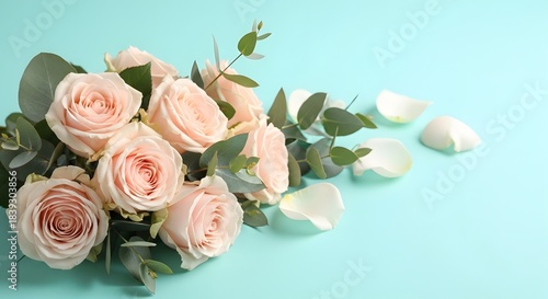 Bouquet of light pink roses with eucalyptus leaves and scattered petals on a light blue background