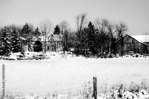 Monochrome of old farm buildings in a winter snow covered landscape
