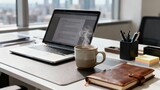 Steaming speckled coffee mug resting beside an open silver laptop displaying a document, with a leather journal on a desk overlooking city buildings.