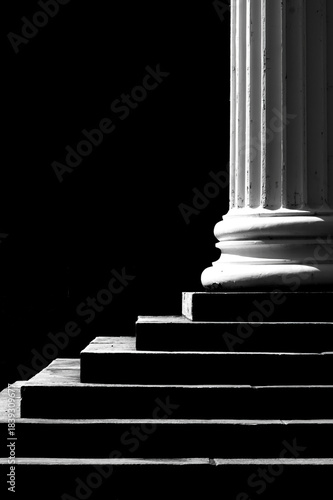 one side lit pillar and steps against dark background for dramatic formal entrance into a building of importance 