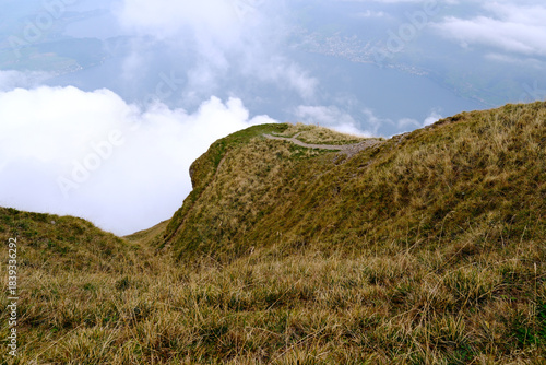 steep mountain ridge in dry alpine grass with clouds on Mount Rigi, Switzerland