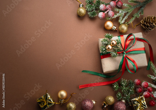 Christmas background with handmade gift box with bow, decorative fir branch, ball and cones for tree decoraton. New Year winter holiday composition with presents, decor and copy space, top view.