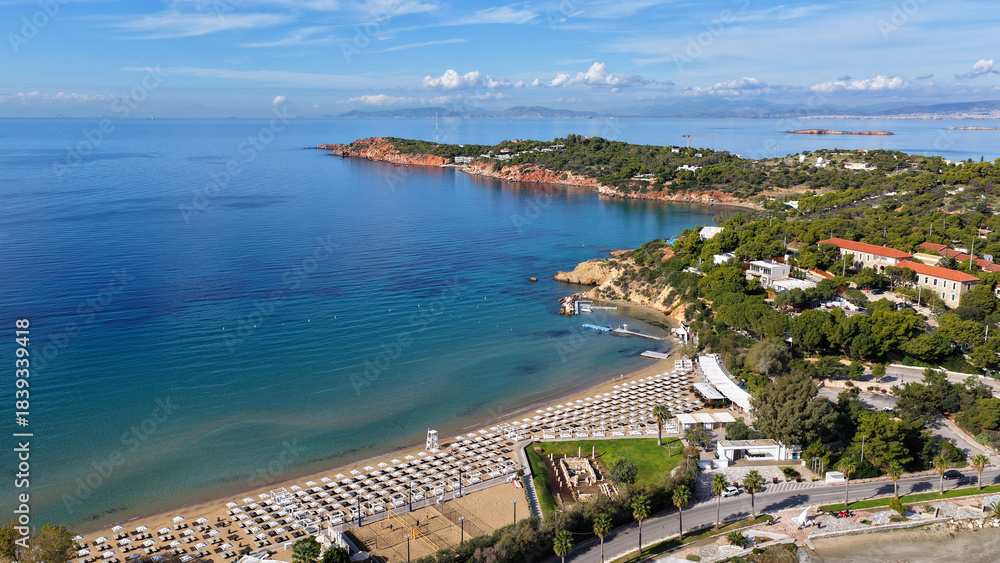 Fototapeta premium Aerial drone photo of amazing organized sandy celebrity beach of Asteras featuring Temple of Apollo Zoster a true ancient cultural heritage, Vouliagmeni, Athens riviera, Greece