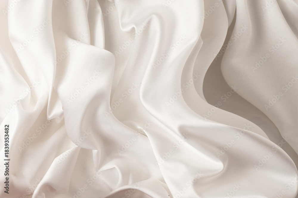 Fototapeta premium Close-up of soft, wavy lines of a satin fabric with a smooth texture in the color of the year 2026 CLOUD DANCER