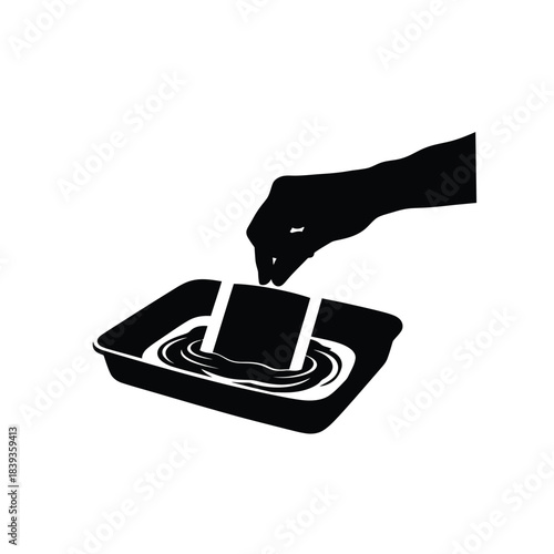 Hand dipping food cubes in a tray silhouette