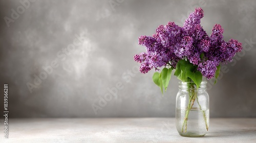 Wallpaper Mural  A vase holding purple blooms rests atop a white table, beside a gray backdrop Torontodigital.ca