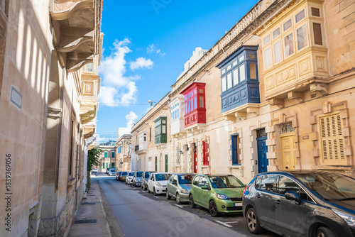 Cozy street and traditional colorful wooden balconies in Sliema, Malta