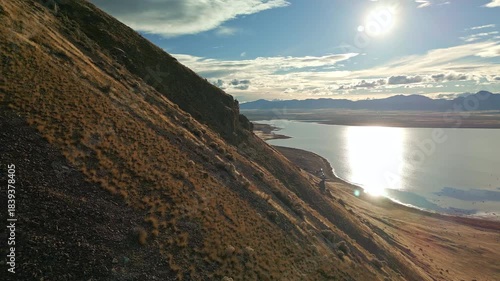 Aerial view flying along the rocky cliffs of West Mountain next to Utah Lake.