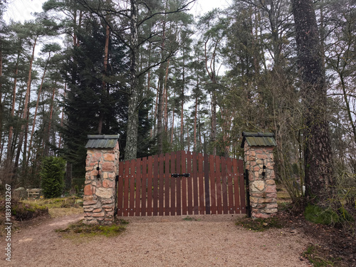 wooden gate, entrance to the cemetery. Stone gateposts. Jaunzemju Cemetery, Latvia, Zemgale