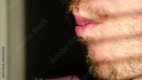 Close up adult man with beard opening his mouth eat piece of fresh maki roll with wooden chopsticks, enjoying delicious japanese meal in restaurant setting. Bearded man eating sushi with chopsticks