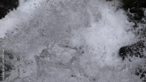 ripresa video al rallentatore con vista molto dettagliata del flusso d'acqua di una cascata di montagna che scorre impetuoso lungo le sue pareti rocciose